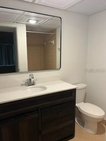a bathroom with a toilet a sink a vanity and mirror
