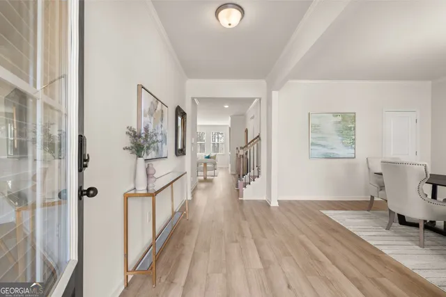 a view of a hallway with wooden floor and furniture