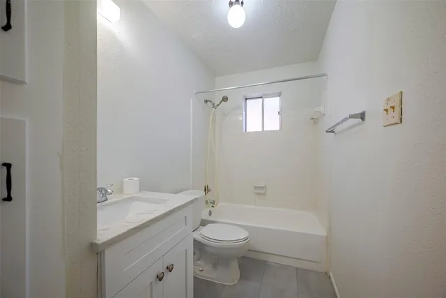 a bathroom with a granite countertop toilet a sink and a mirror