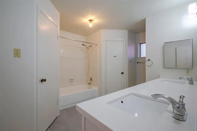 a bathroom with a tub sink and mirror