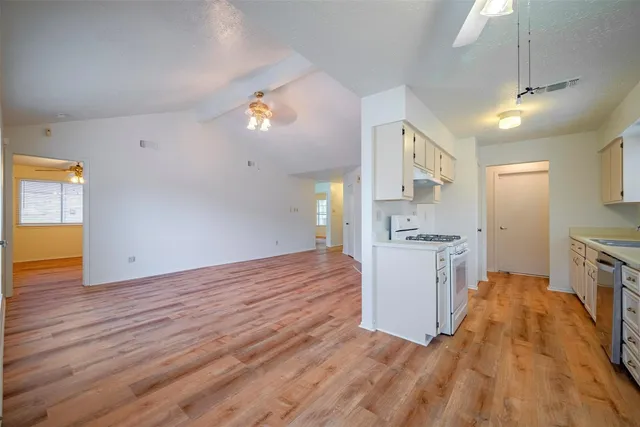 a view of a kitchen with a sink and dishwasher with wooden floor