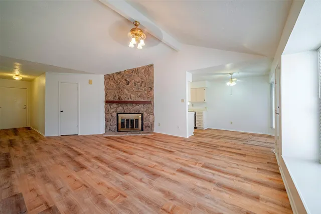 a view of an empty room with a fireplace and a window