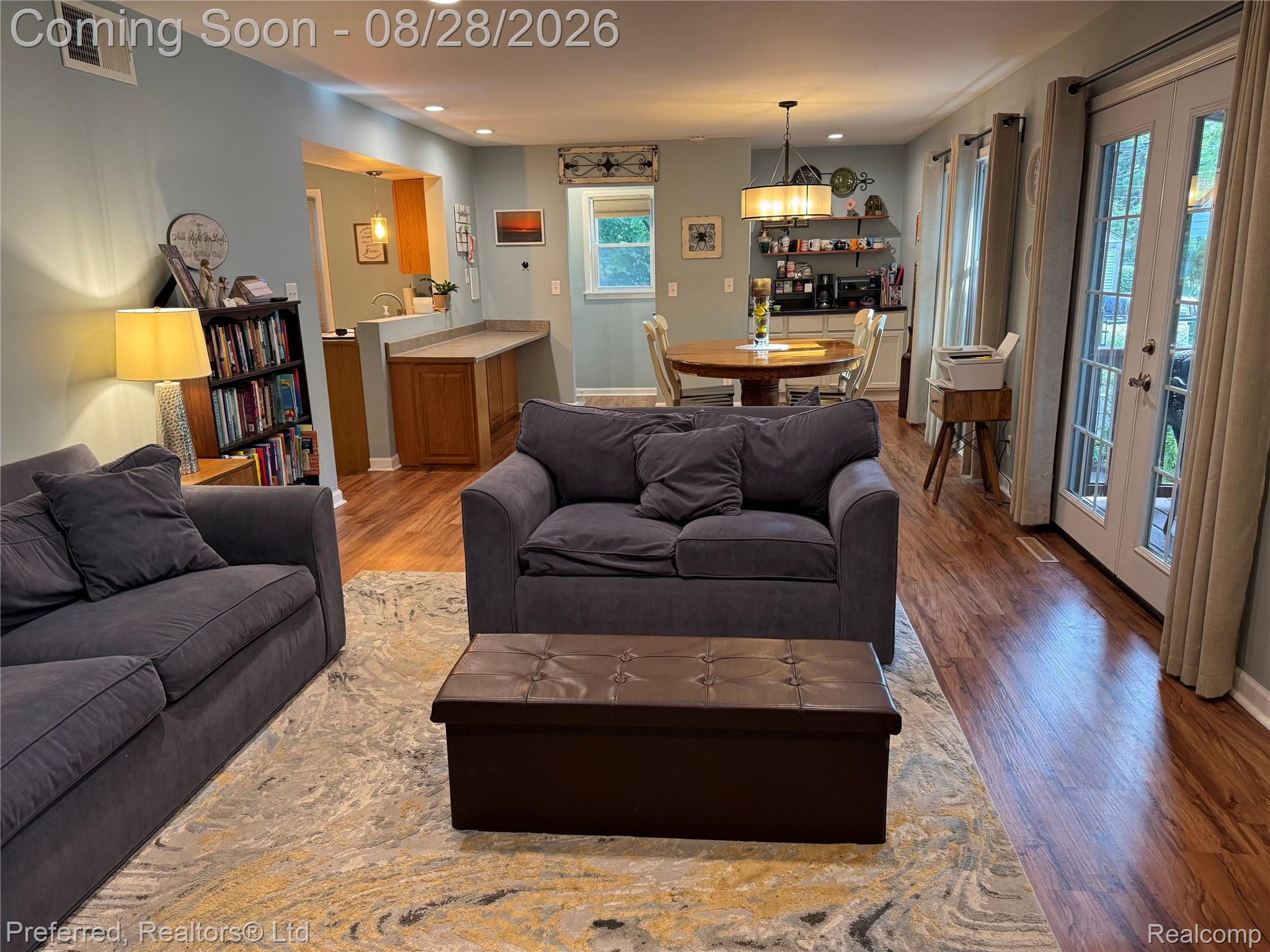 10362 Quirk Road Belleville, MI 48111 - Photo 15 of 41 Hardwood-finish flooring, built-in shelving, kitchen pass-through with wood cabinetry, and French doors to the exterior