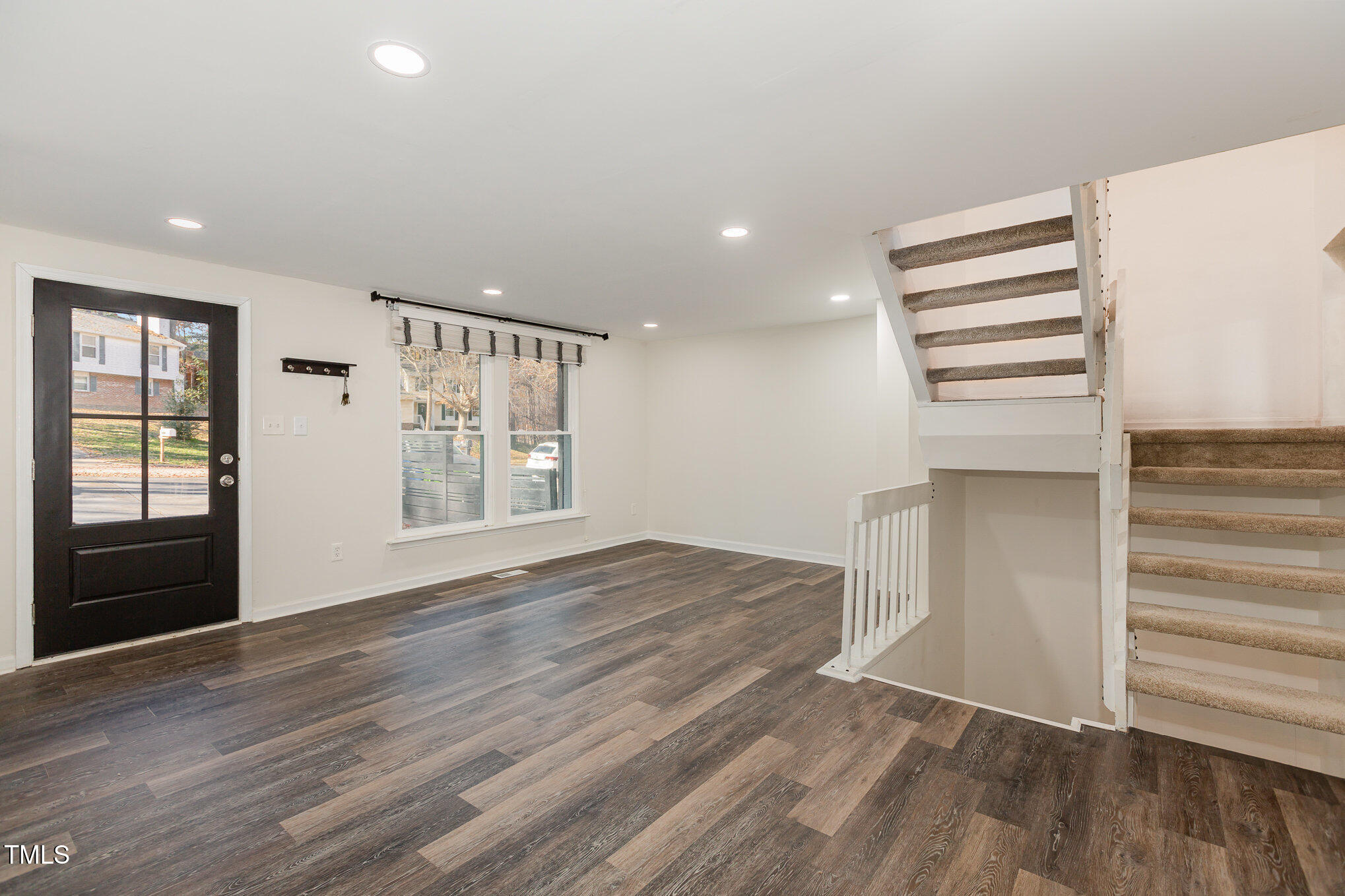 7324 Summerland Drive Raleigh, NC 27612 - Photo 3 of 24 an empty room with wooden floor cabinet and windows
