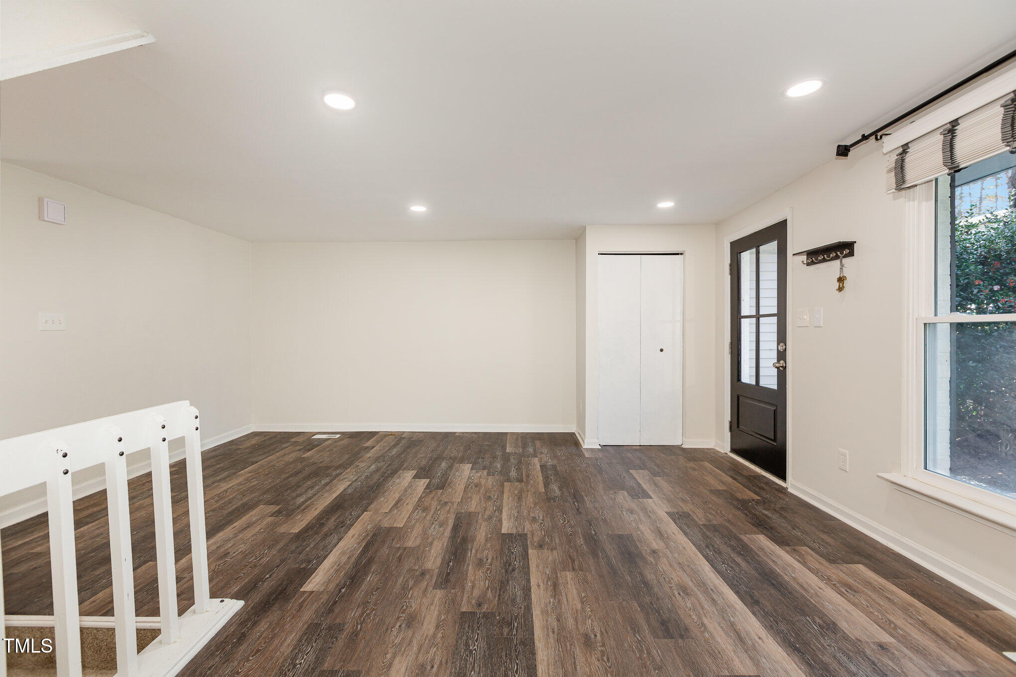 7324 Summerland Drive Raleigh, NC 27612 - Photo 4 of 24 a view of an empty room with wooden floor and a window