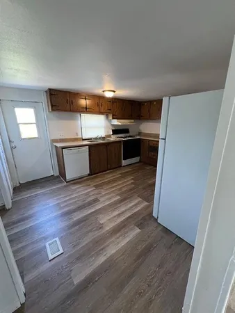 a view of a kitchen with wooden floor and electronic appliances