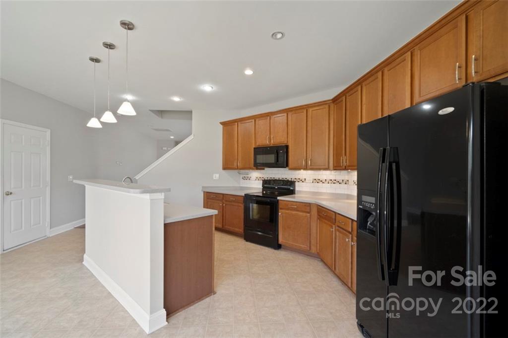 4416 Marys Point Road Monroe, NC 28110 - Photo 8 of 33 a kitchen with a refrigerator a stove top oven and cabinets