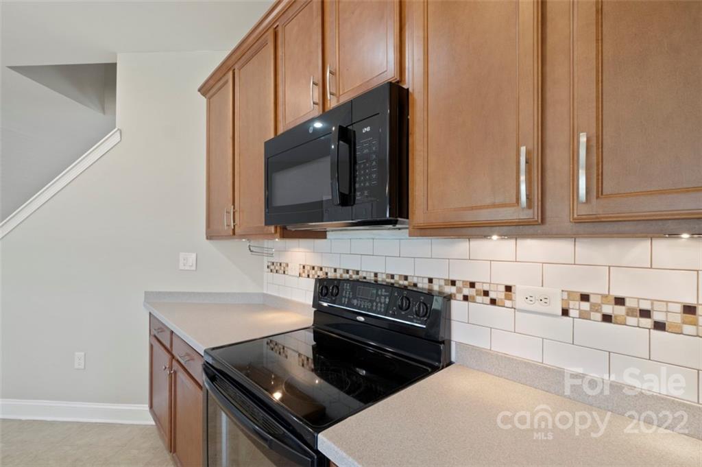 4416 Marys Point Road Monroe, NC 28110 - Photo 10 of 33 a kitchen with stainless steel appliances wooden cabinets and a stove top oven