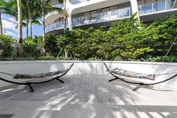 a view of an chairs and table in patio next to a yard
