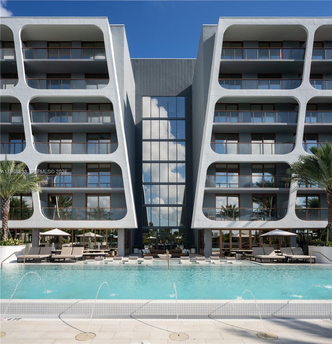 3900 Alton Road, Unit 318 Miami Beach, FL 33140 - Photo 4 of 42 a front view of multi story residential apartment building with yard