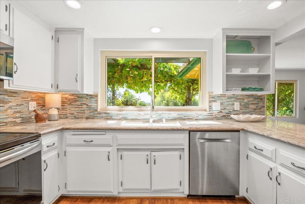 485 Wax Flower Lane Fallbrook, CA 92028 - Photo 3 of 31 a kitchen with granite countertop a sink and white cabinets