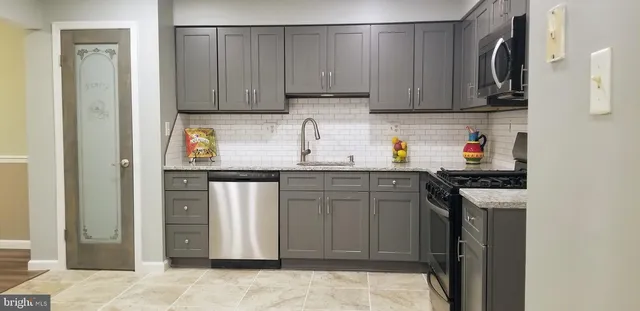 a kitchen with stainless steel appliances granite countertop a refrigerator and a stove top oven