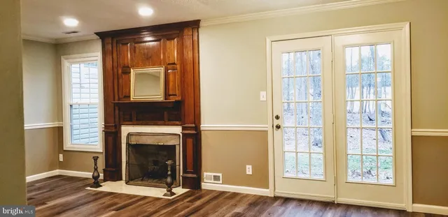 an empty room with wooden floor and a fireplace