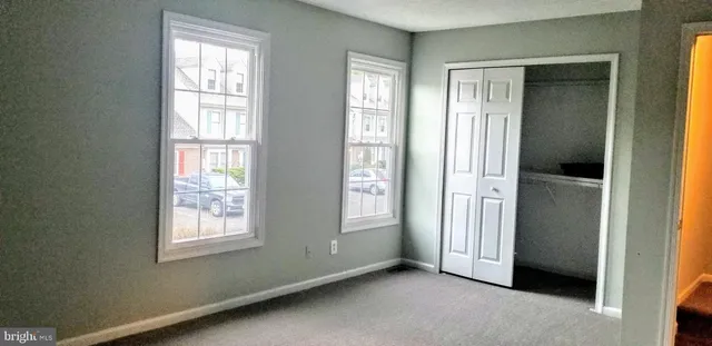 an empty room with windows and closet