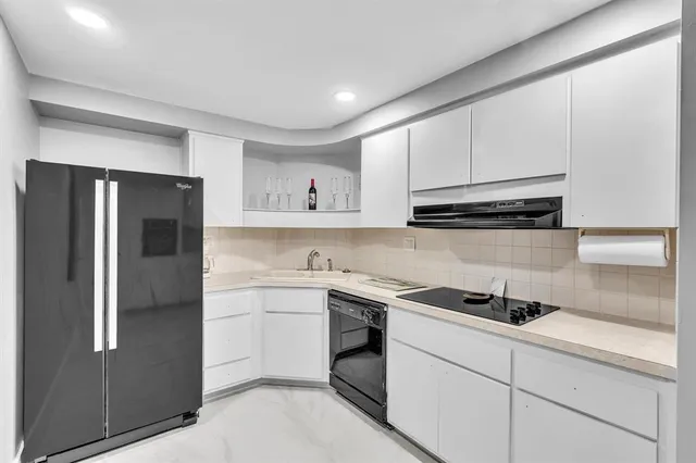 a kitchen with cabinets and a refrigerator