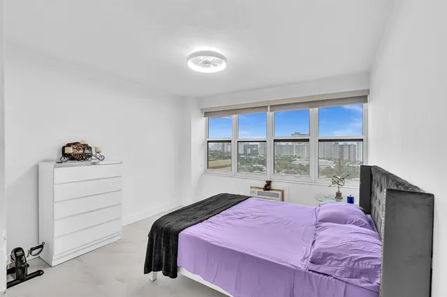 a bedroom with a bed and a large window