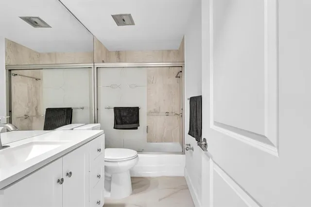 a bathroom with a sink toilet a mirror and shower