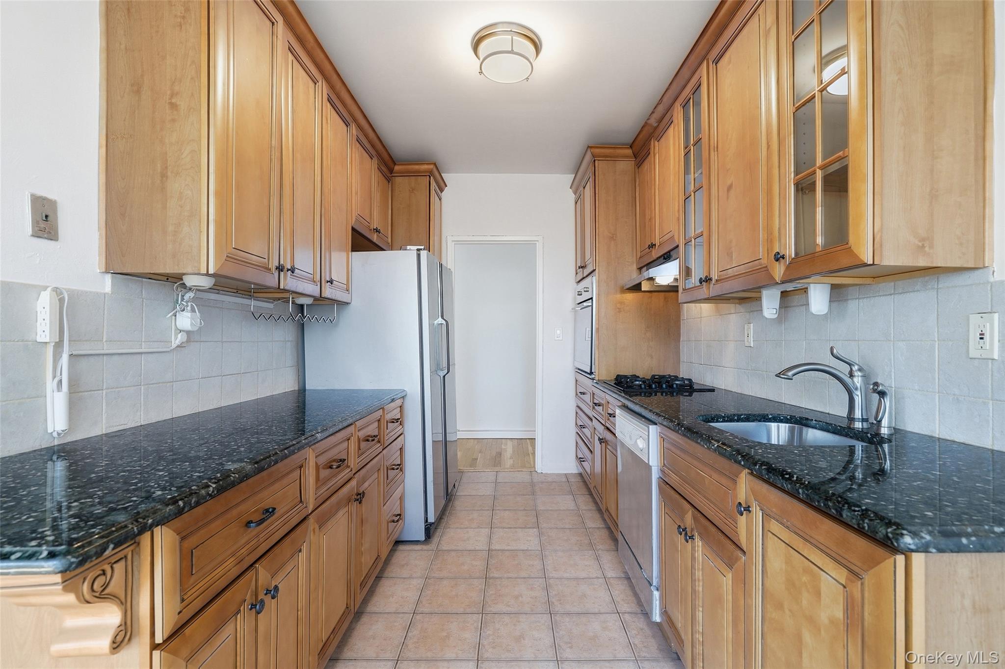 953 West Boston Post Road, Unit 3O Mamaroneck, NY 10543 - Photo 8 of 22 a kitchen with stainless steel appliances granite countertop a sink and a stove