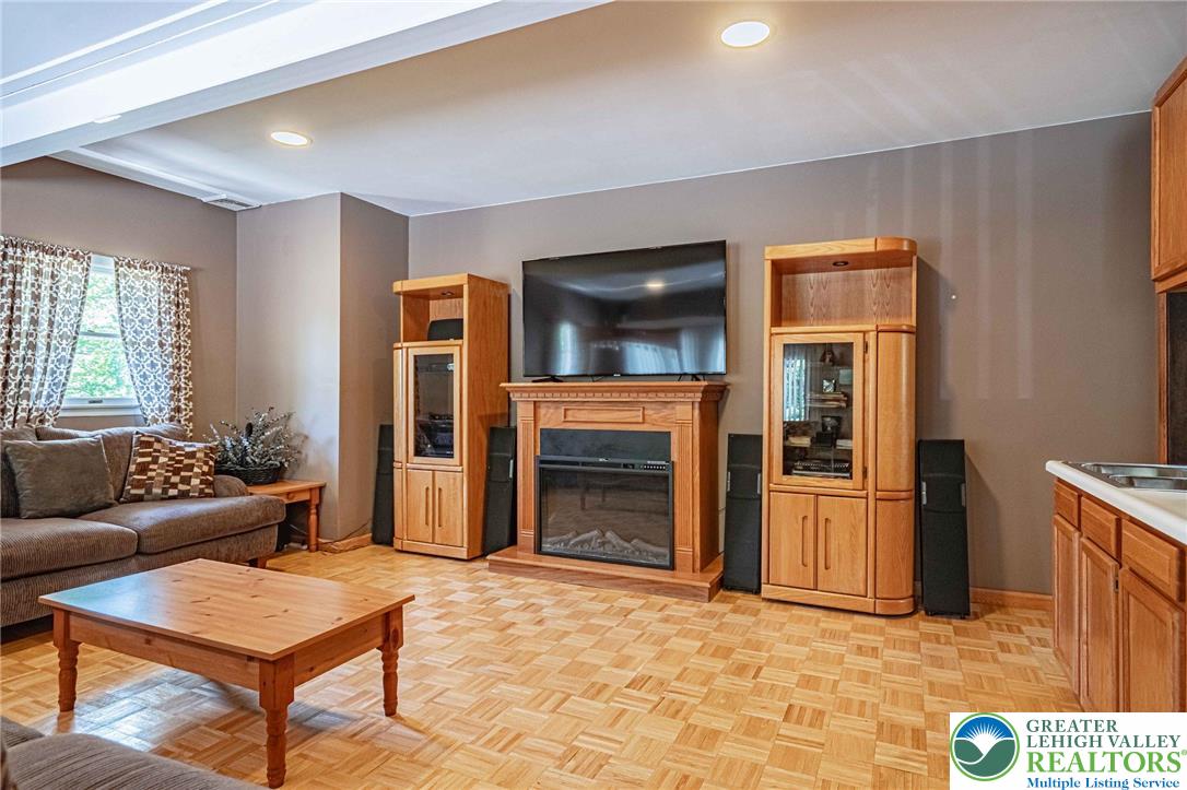 3857 Friedens Road Slatington, PA 18080 - Photo 20 of 75 This inviting living space features warm parquet flooring and a cozy fireplace, perfect for daily living.
