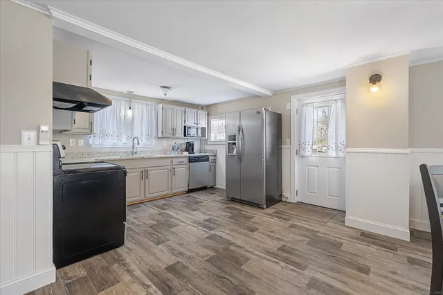 a kitchen with a sink a refrigerator and cabinets