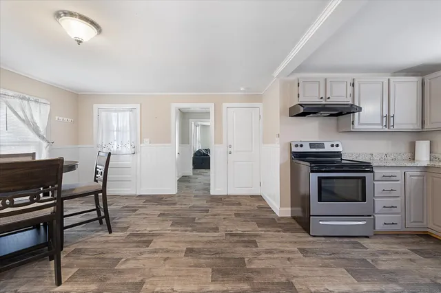 a kitchen with stainless steel appliances a stove a sink cabinets and a window