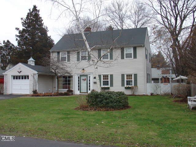 a front view of a house with a yard and trees