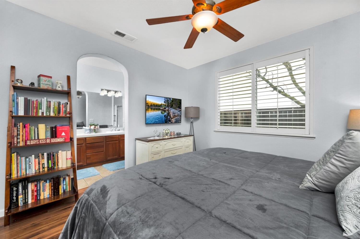 1968 North Tuscany Lane Clovis, CA 93619 - Photo 15 of 40 a spacious bedroom with a bed a book shelf and a window