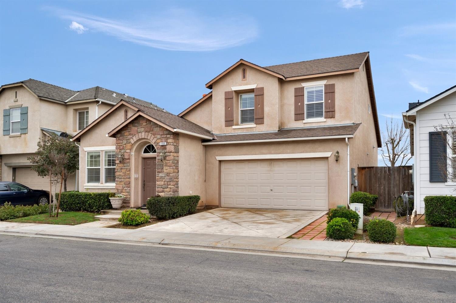 1968 North Tuscany Lane Clovis, CA 93619 - Photo 33 of 40 a front view of a house with a yard and garage