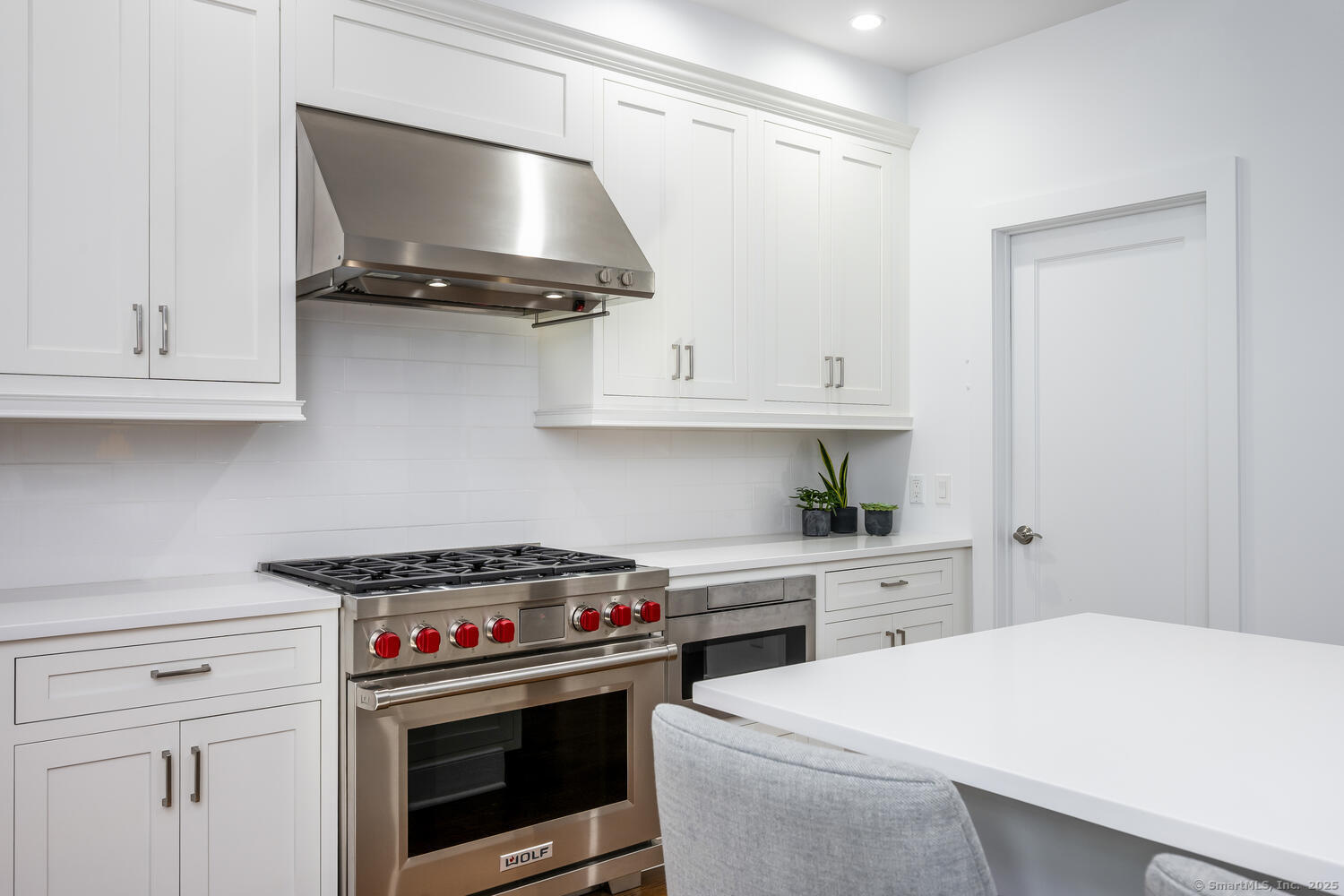 72 Kensett Lane Darien, CT 06820 - Photo 16 of 39 a kitchen with stainless steel appliances a white stove and white cabinets
