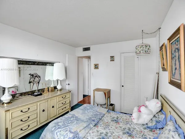 a spacious bedroom with a bed and a dresser in it