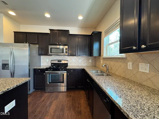 a kitchen with granite countertop stainless steel appliances and wooden cabinets