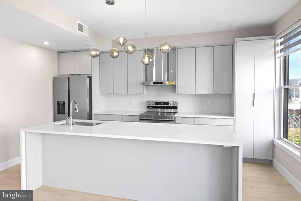 a kitchen with stainless steel appliances a sink stove and refrigerator