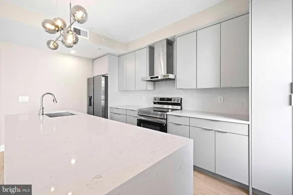 a kitchen with stainless steel appliances a white cabinets and stove top oven