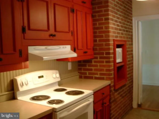 a view of empty room with wooden floor and fireplace