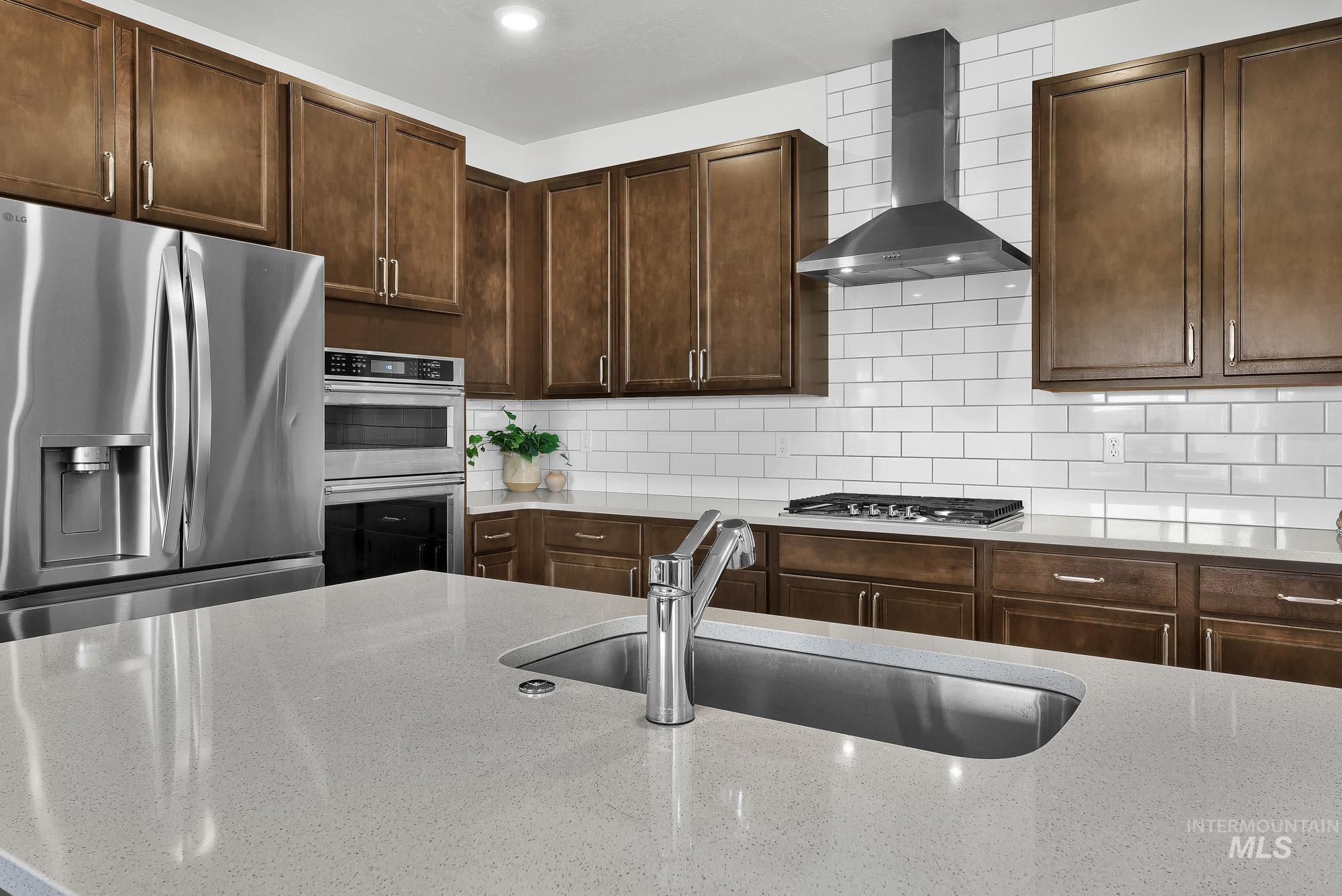 717 West Lyra Street Meridian, ID 83642 - Photo 13 of 50 Kitchen featuring light-toned stone countertops and a white subway tile backsplash