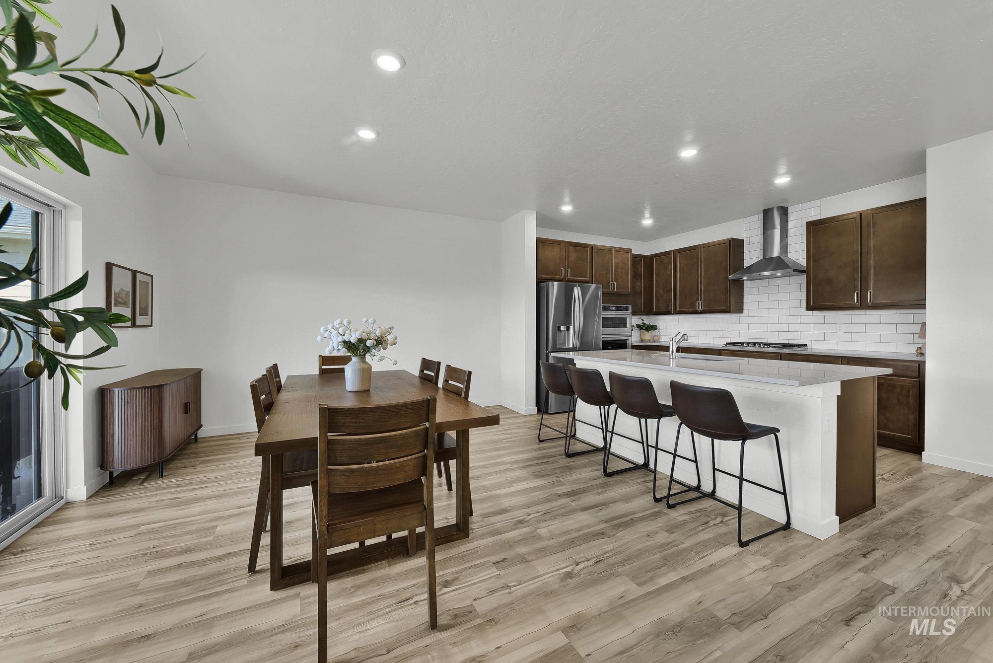 717 West Lyra Street Meridian, ID 83642 - Photo 18 of 50 Open-concept living space featuring wood-finish flooring, recessed lighting, and a sliding glass door