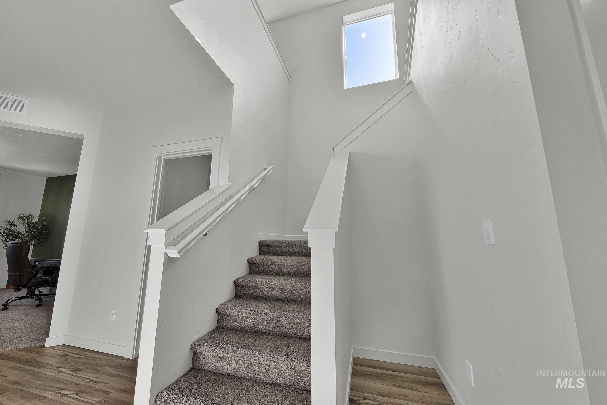 717 West Lyra Street Meridian, ID 83642 - Photo 21 of 50 Staircase featuring carpeted treads, white painted risers, and a contemporary white railing