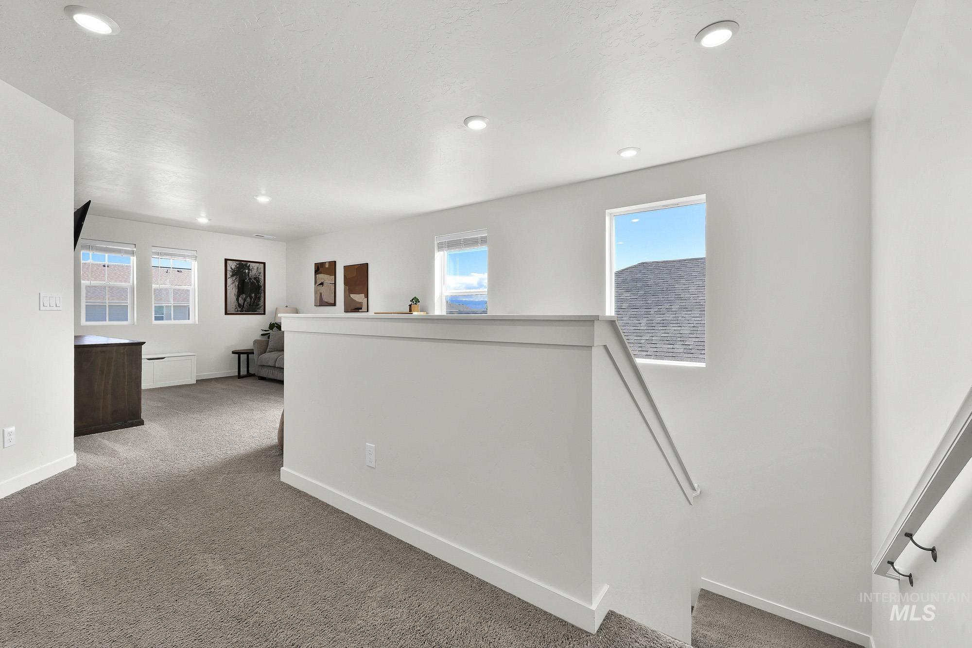717 West Lyra Street Meridian, ID 83642 - Photo 22 of 50 Spacious upper-level living area with recessed lighting, multiple windows providing natural light, and plush carpet flooring