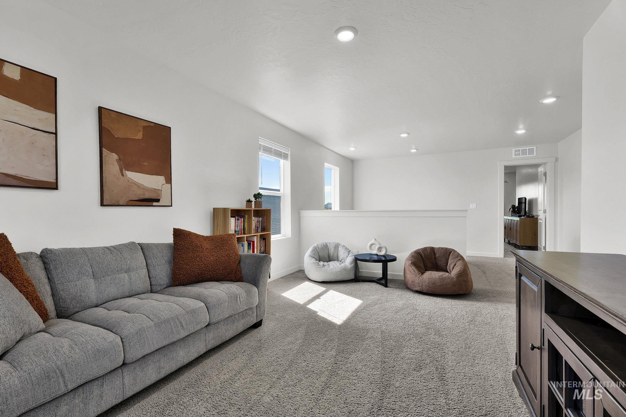 717 West Lyra Street Meridian, ID 83642 - Photo 24 of 50 Carpeted loft area featuring white walls, recessed lighting, and multiple windows providing natural light
