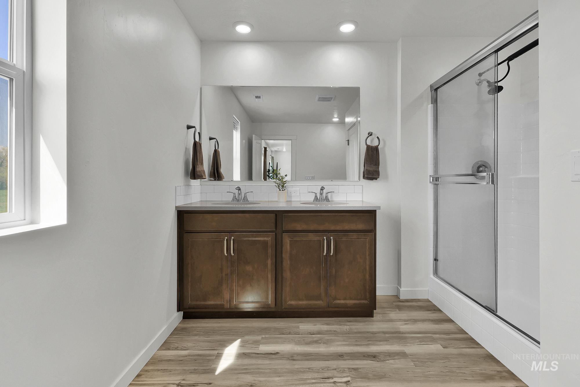 717 West Lyra Street Meridian, ID 83642 - Photo 31 of 50 Double vanity with wood-finish cabinetry, white countertop, and tile backsplash