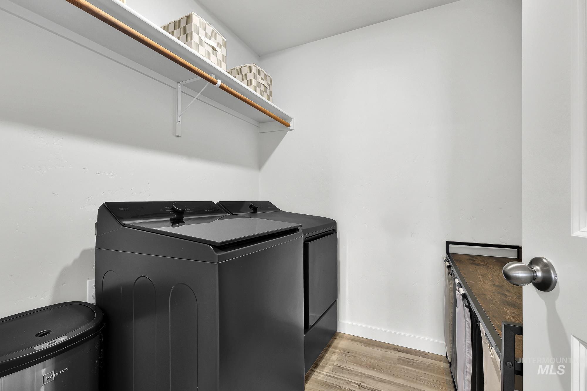 717 West Lyra Street Meridian, ID 83642 - Photo 47 of 50 Laundry area featuring white walls, wood-finish flooring, a wall-mounted white shelf with a wood rod, and a built-in organizational unit with a wood-finish countertop