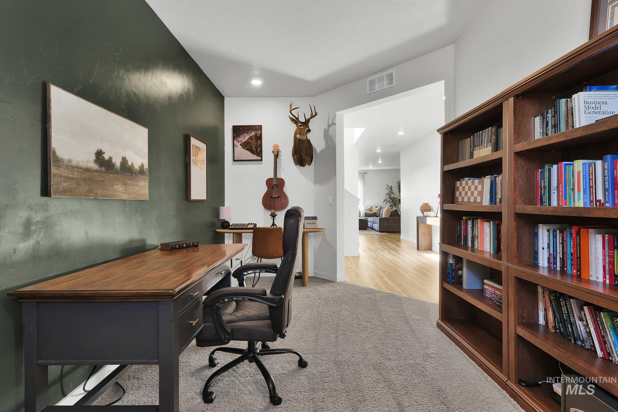 717 West Lyra Street Meridian, ID 83642 - Photo 6 of 50 Dedicated room featuring a built-in wood bookcase, a textured accent wall, recessed lighting, and carpet flooring