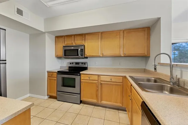 a kitchen with sink a microwave and stove top oven
