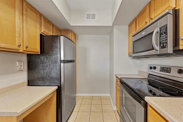 a kitchen with stainless steel appliances granite countertop a refrigerator and a stove top oven