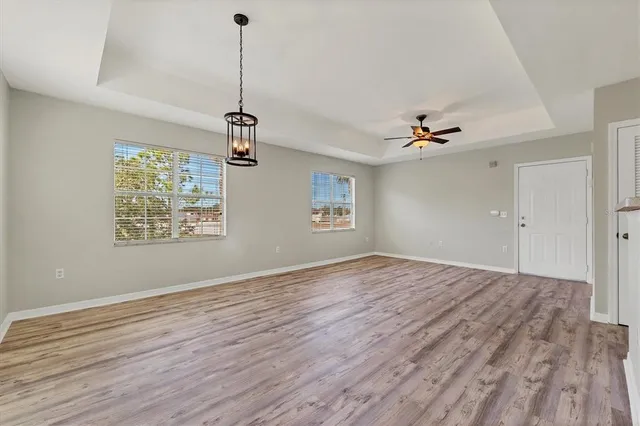 a view of empty room with wooden floor and ceiling fan