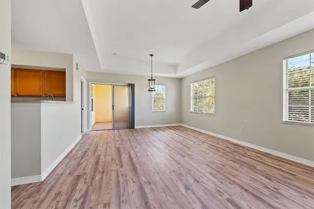 a view of an empty room with window and wooden floor