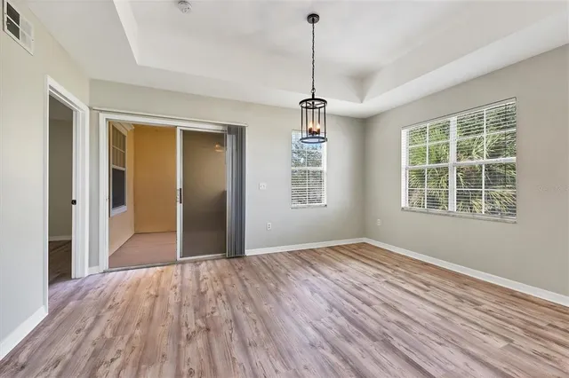 a view of empty room with wooden floor and windows