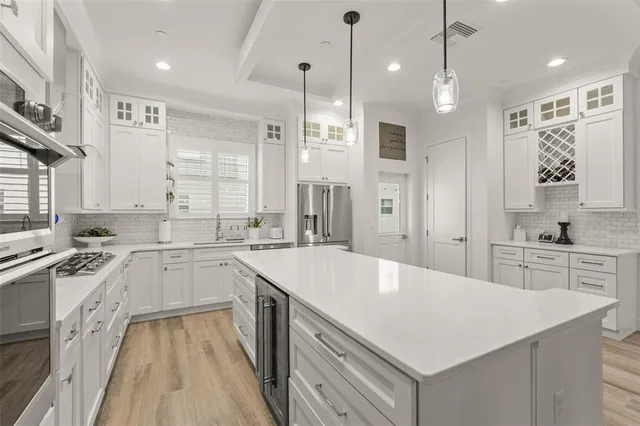 a large white kitchen with a sink stove and refrigerator