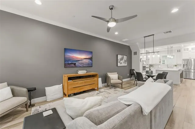 a living room with furniture a chandelier and a flat screen tv