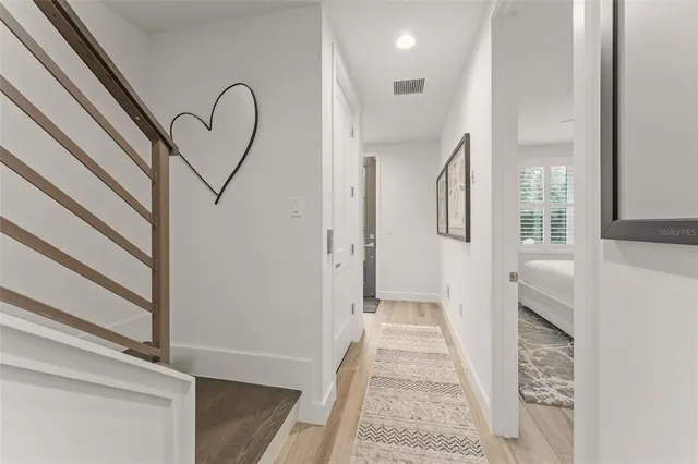 a view of a hallway with wooden floor and staircase